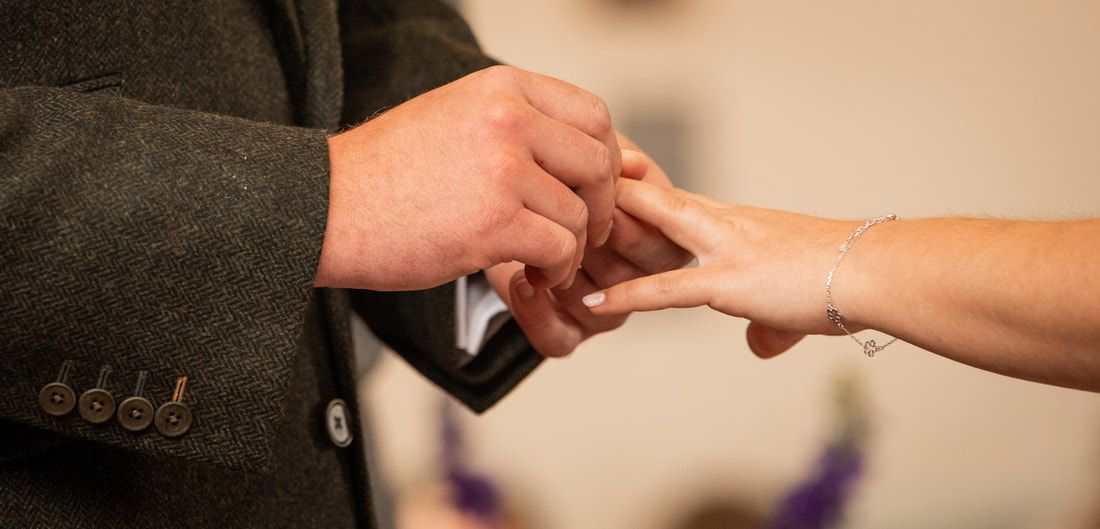 A hand extends a credit card to make a payment in a retail transaction setting.