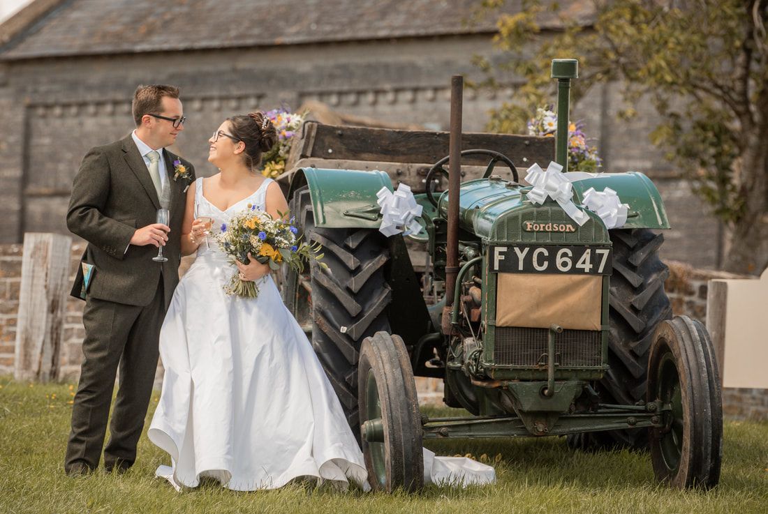A vintage green military vehicle parked outdoors serves as a backdrop for a rustic countryside celebration.