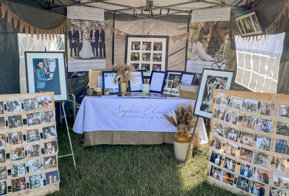 Wide view of an outdoor photography exhibition tent with multiple display boards.