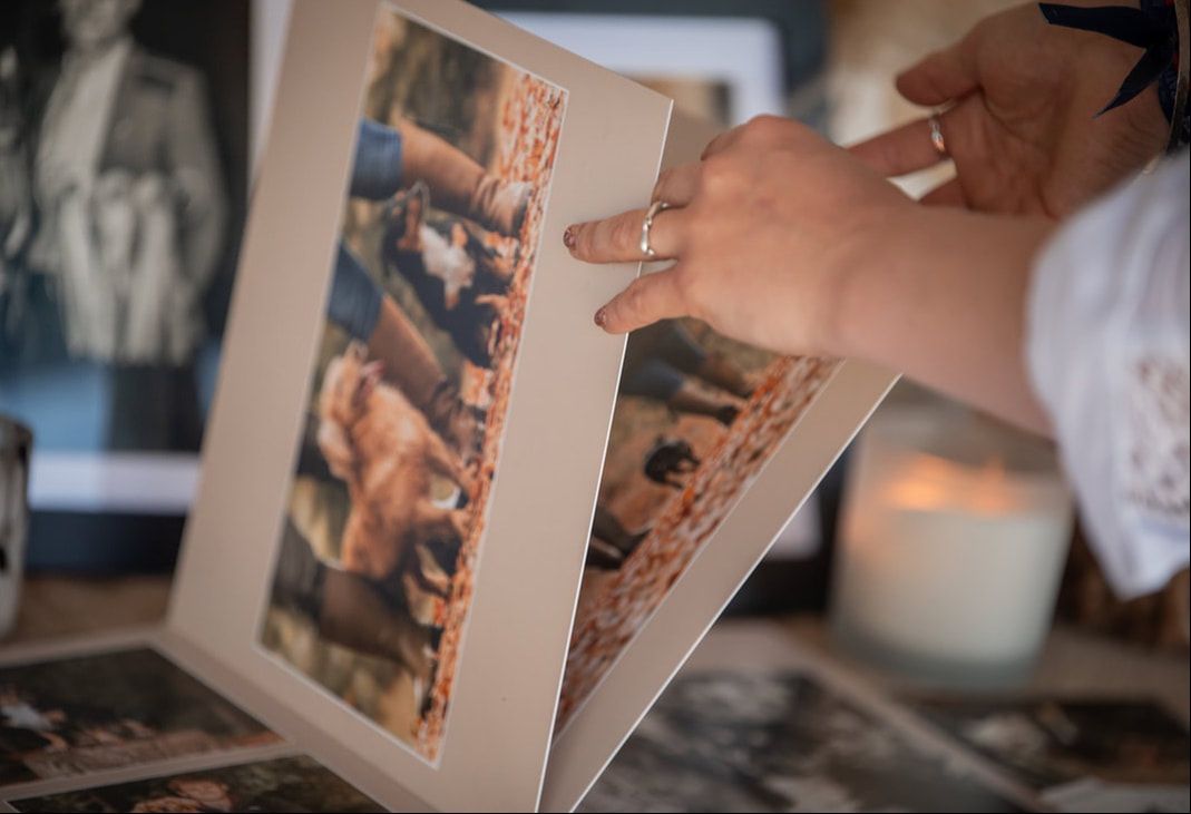 Hands gently flip through pages of a photo album showing cherished family memories and moments.