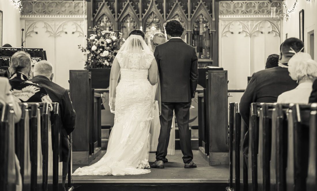 A series of black and white wedding ceremony photos arranged in a filmstrip-style collage showing different moments.