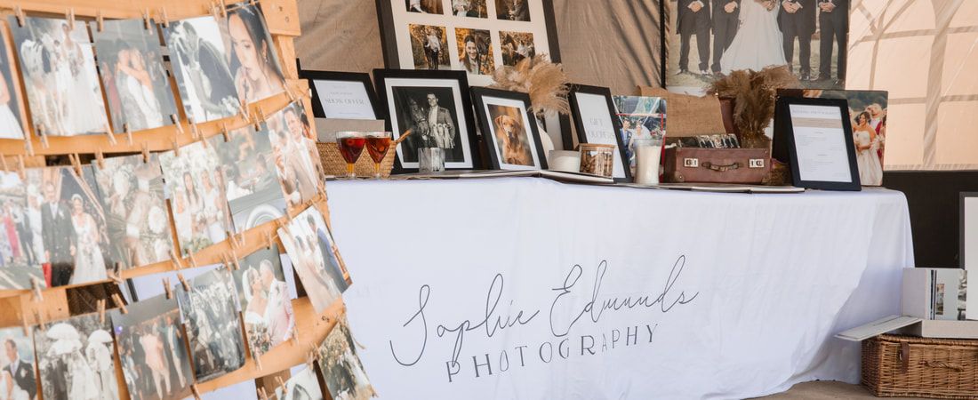 A collage of vintage photographs and artwork displayed on a rustic wall with handwritten notes and personal memorabilia.