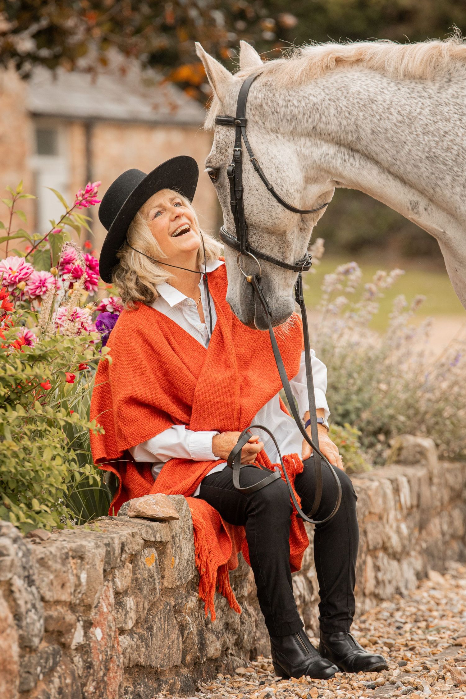 Four sequential photos showing a person in a red coat sitting on a stone wall with a white horse in a garden setting.