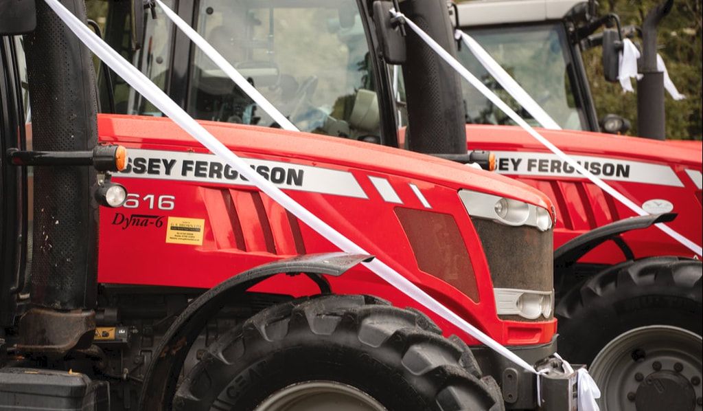 Red Massey Ferguson tractors on display at an agricultural equipment dealership lot.