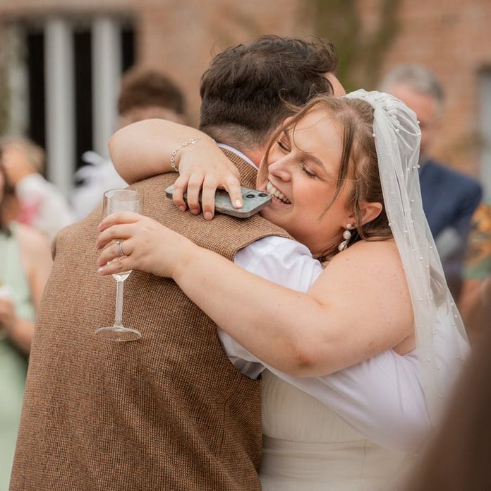 Wedding couple shares an intimate embrace during their first dance at an indoor reception venue.