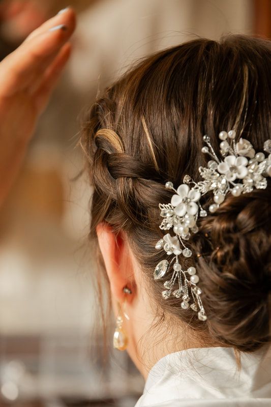 Delicate crystal and pearl floral hair accessories adorn an elegant bridal updo hairstyle.