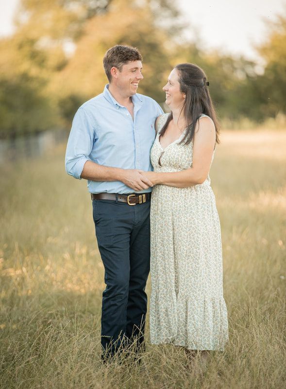 A couple shares tender moments in a sun-drenched field during a romantic golden hour photoshoot.