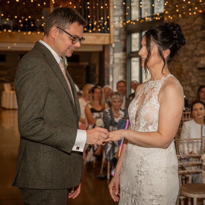 A couple shares their first dance at a wedding reception with twinkling lights in the background.