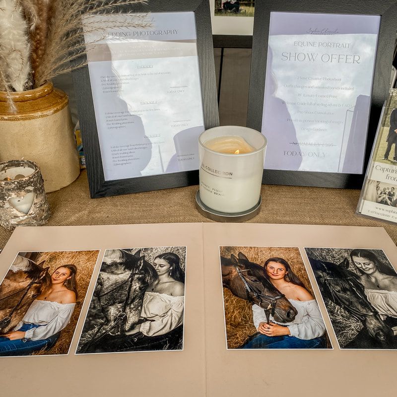 Collection of black and white photographs displayed with candles and text layouts on a table.