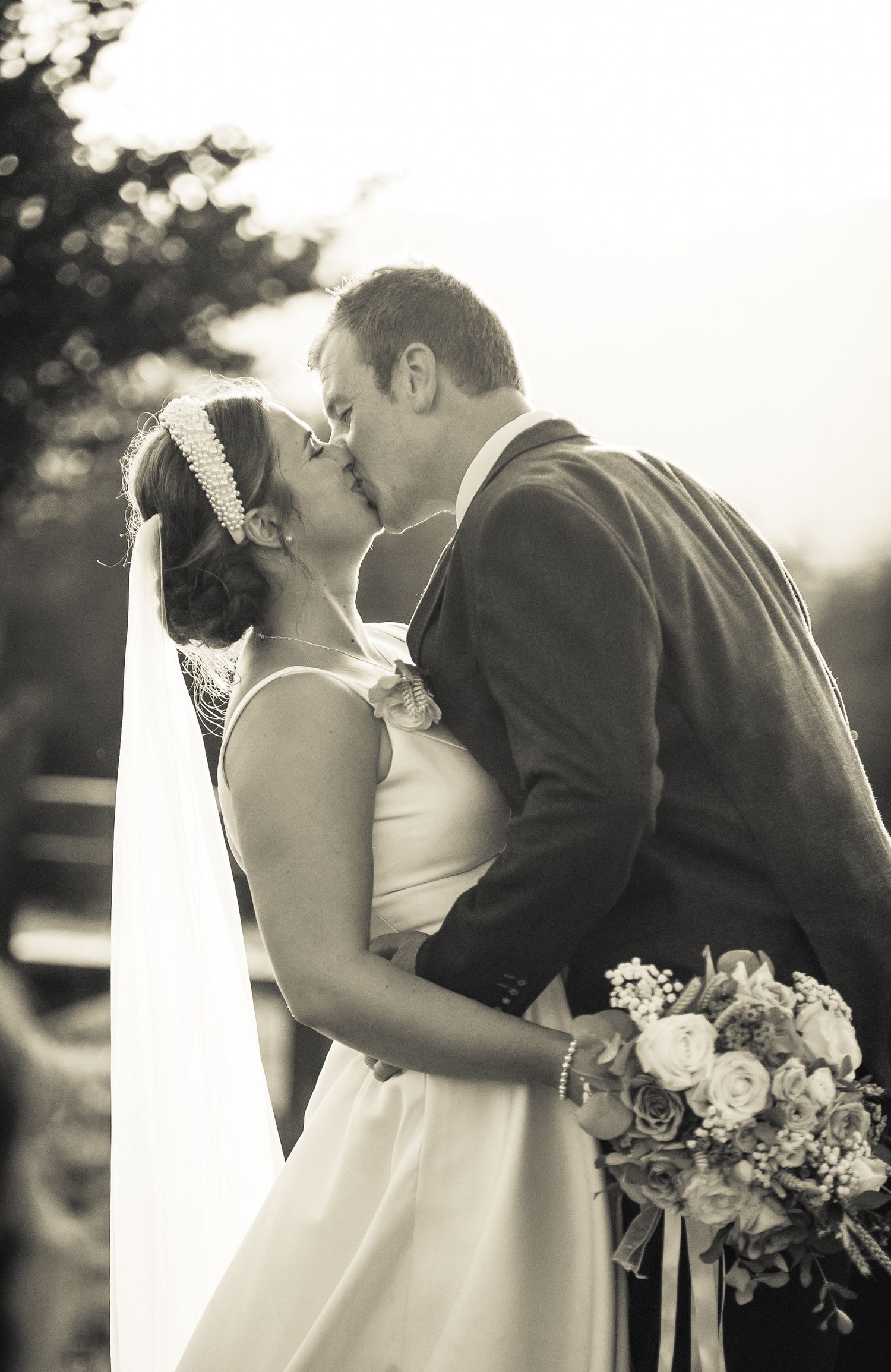 A romantic wedding moment captured in soft black and white tones.