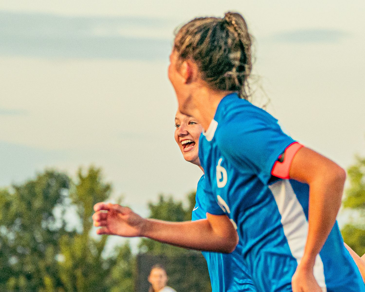 A soccer player smiling after scoring