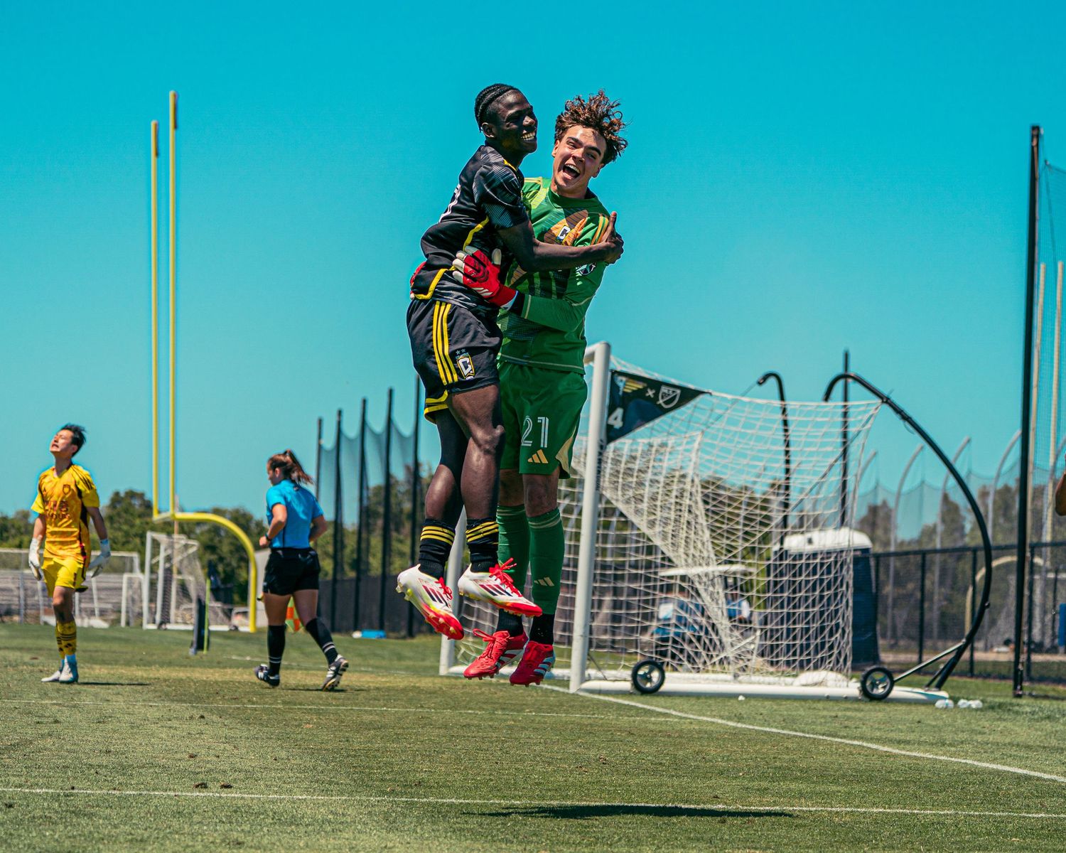 Two soccer players celebrating a win
