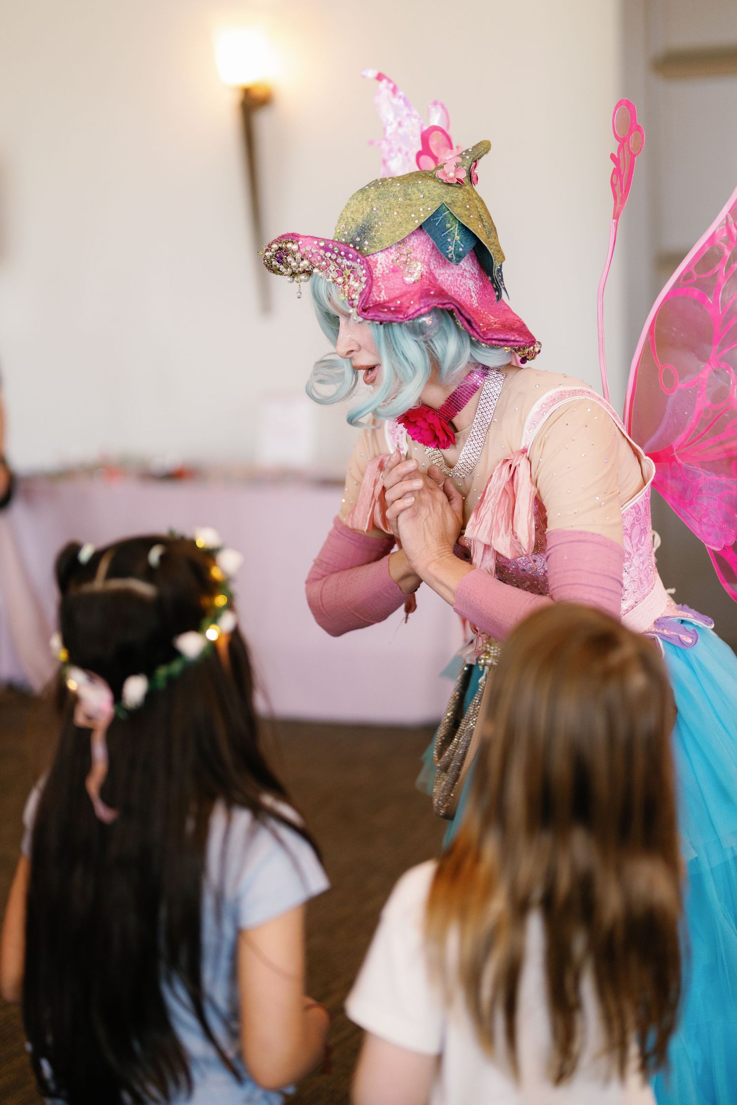 Magical party performance with pink and blue costumes and fairy wands in action.