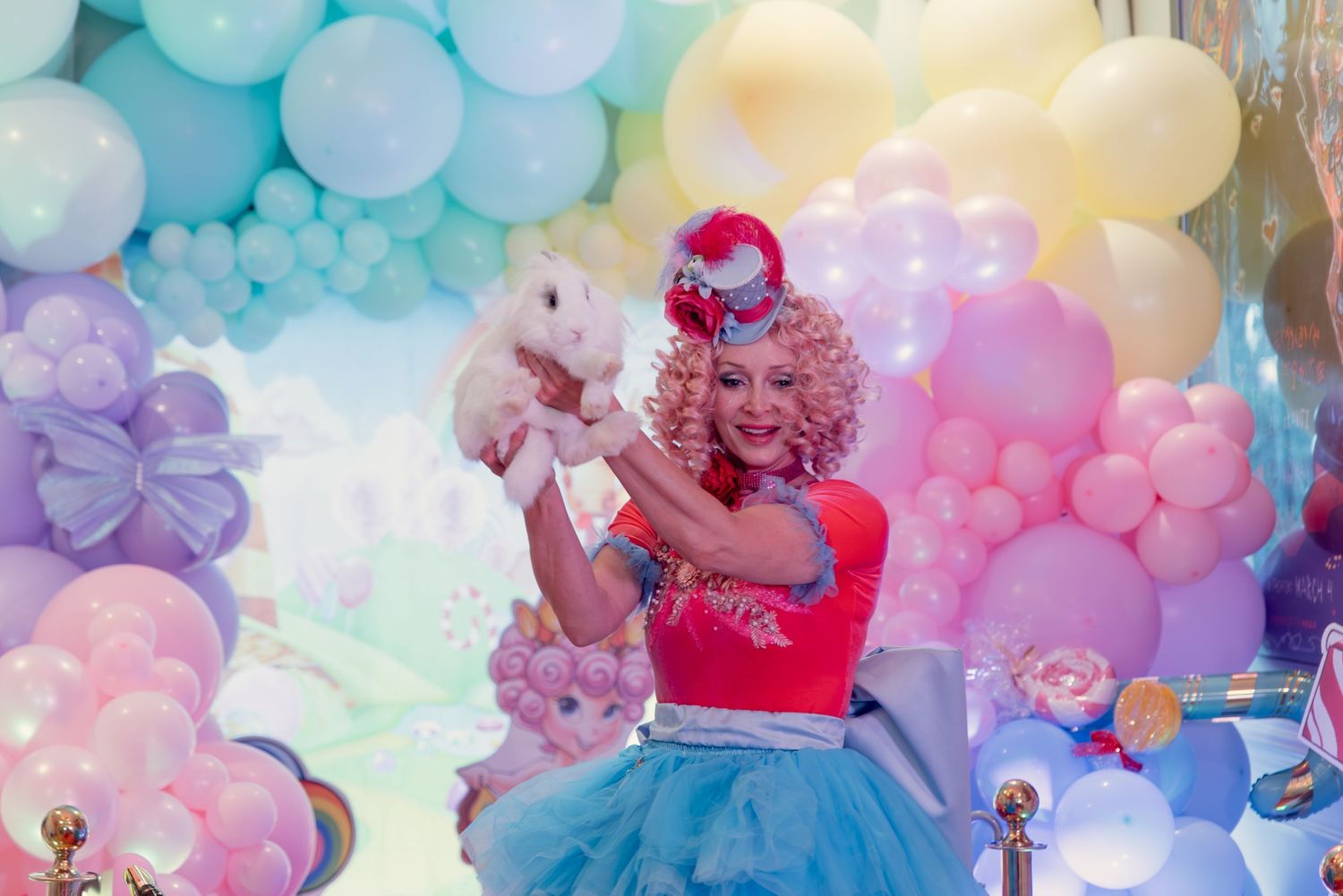 Colorful pastel balloon arch decorations with pink, blue, and purple hues create a dreamy party atmosphere.