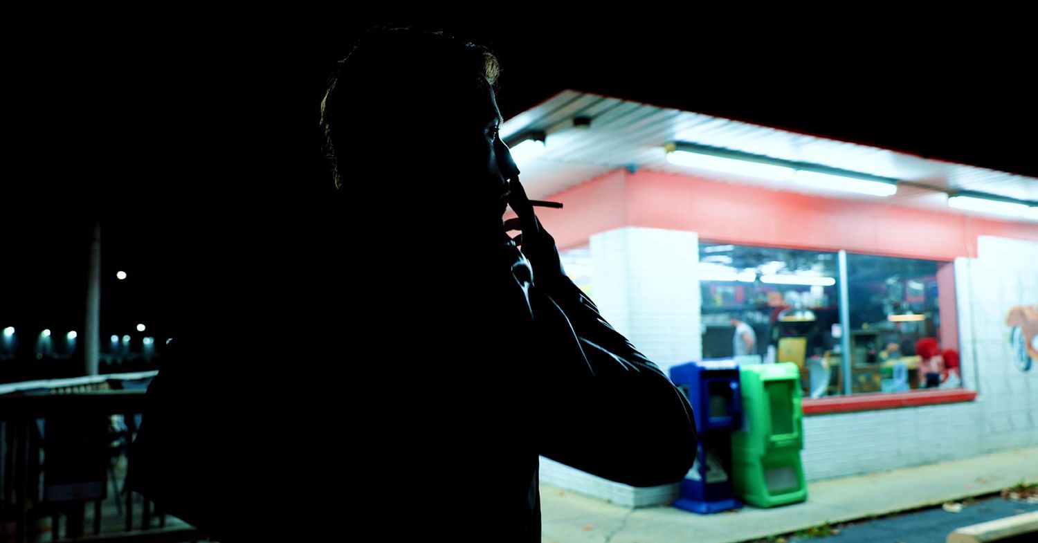A dark silhouetted figure of the artist 
