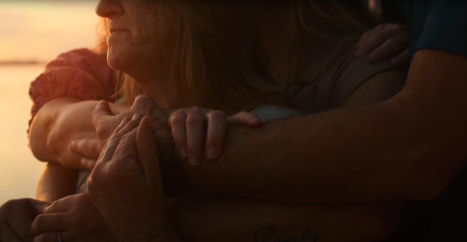 A tender embrace captured in warm sunset lighting.