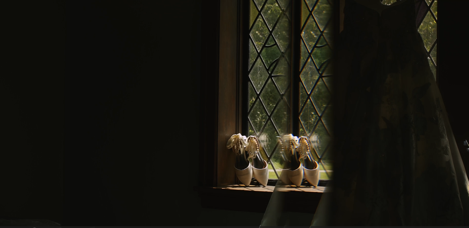 Three delicate floral arrangements sit in front of a stained glass window.