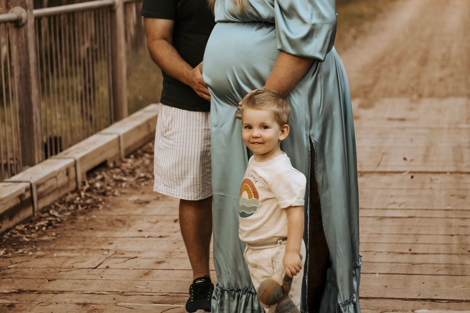 Expectant mother laughing with her partner and son in the bushlands