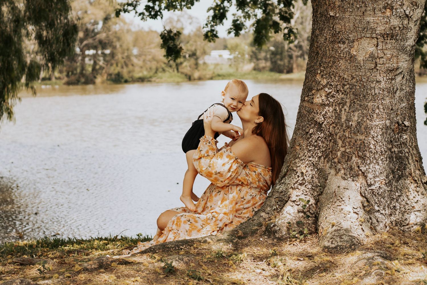 Pregnant mother sitting at the pond with her son during a morning maternity photography session in Hervey Bay.