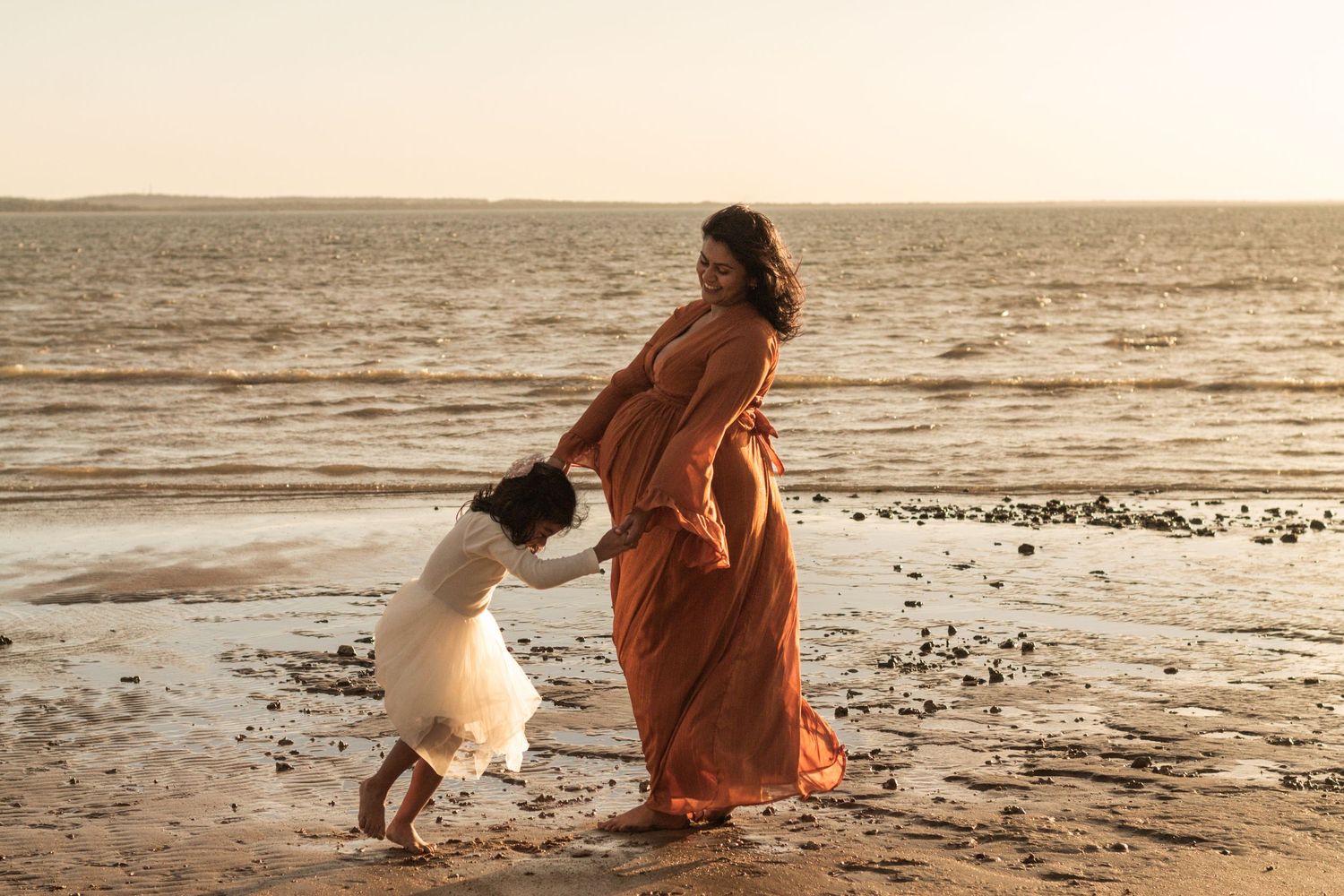 Mother and Daughter playing at the beach during a Sunset maternity photography session in Fraser Coast.