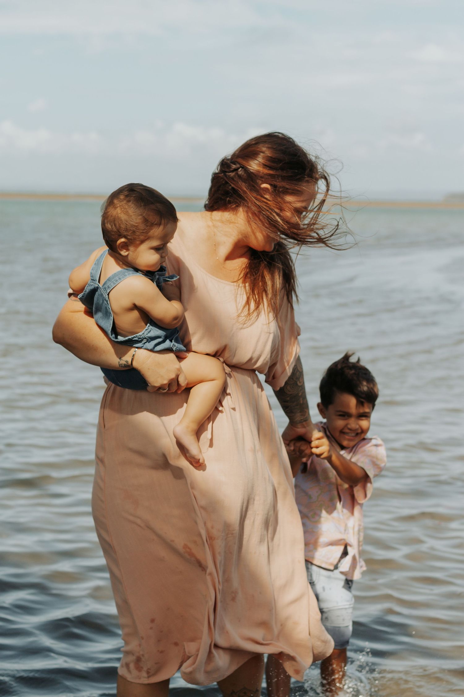 Mother and her two boys playing at the beach during a Morning family photography session in Hervey Bay.