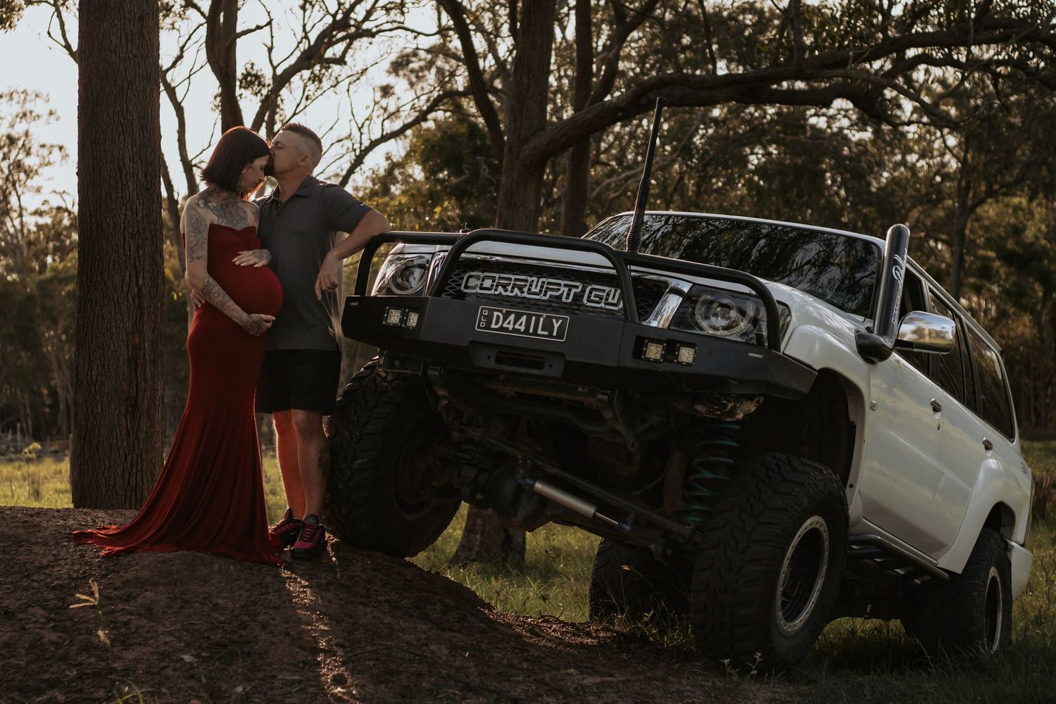 Mother and Father to be cuddling their first baby bump together during a relaxed outdoor motherhood photography session in Hervey Bay.
