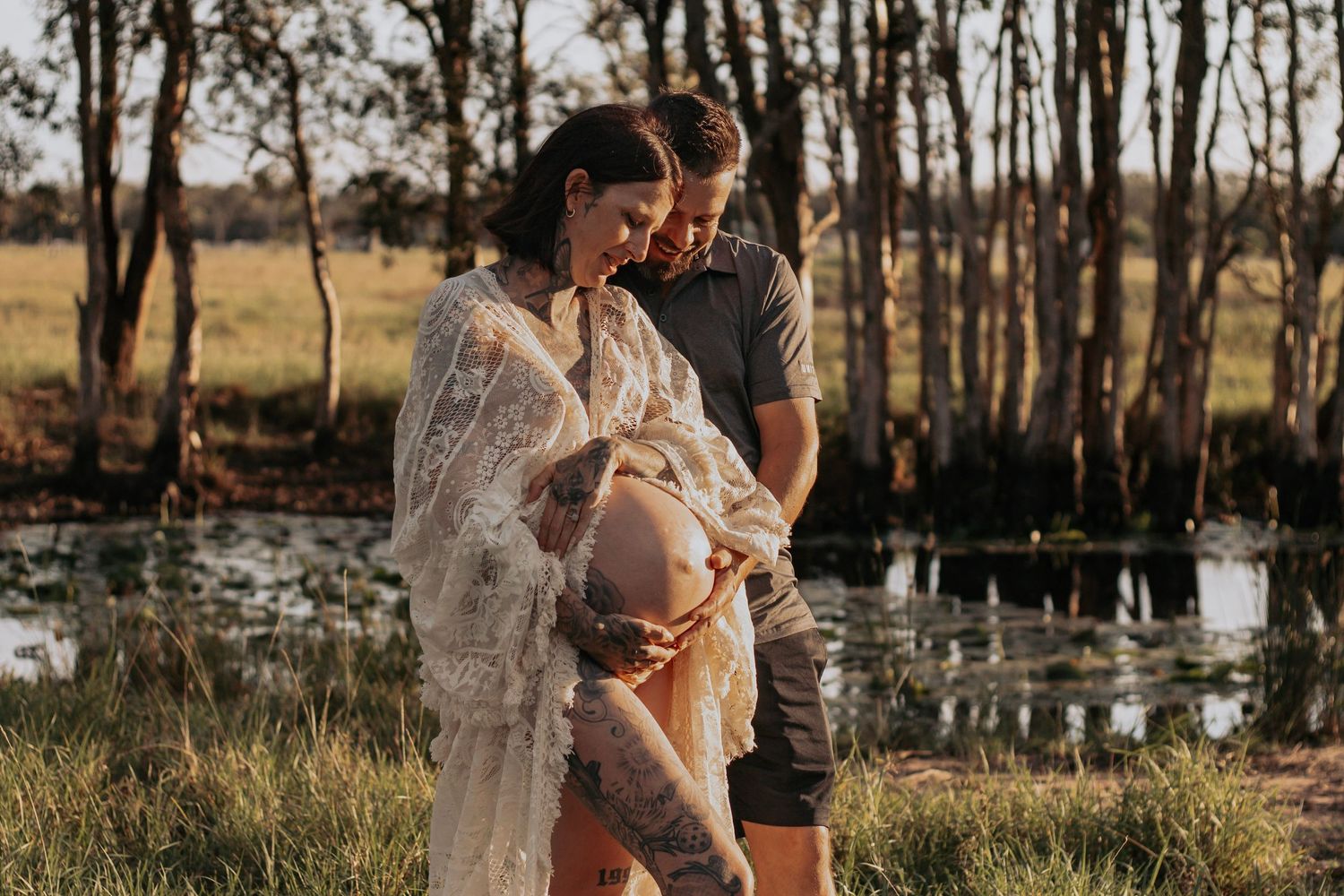 Mother and Father to be cuddling their first baby bump together during a relaxed outdoor motherhood photography session in Hervey Bay.