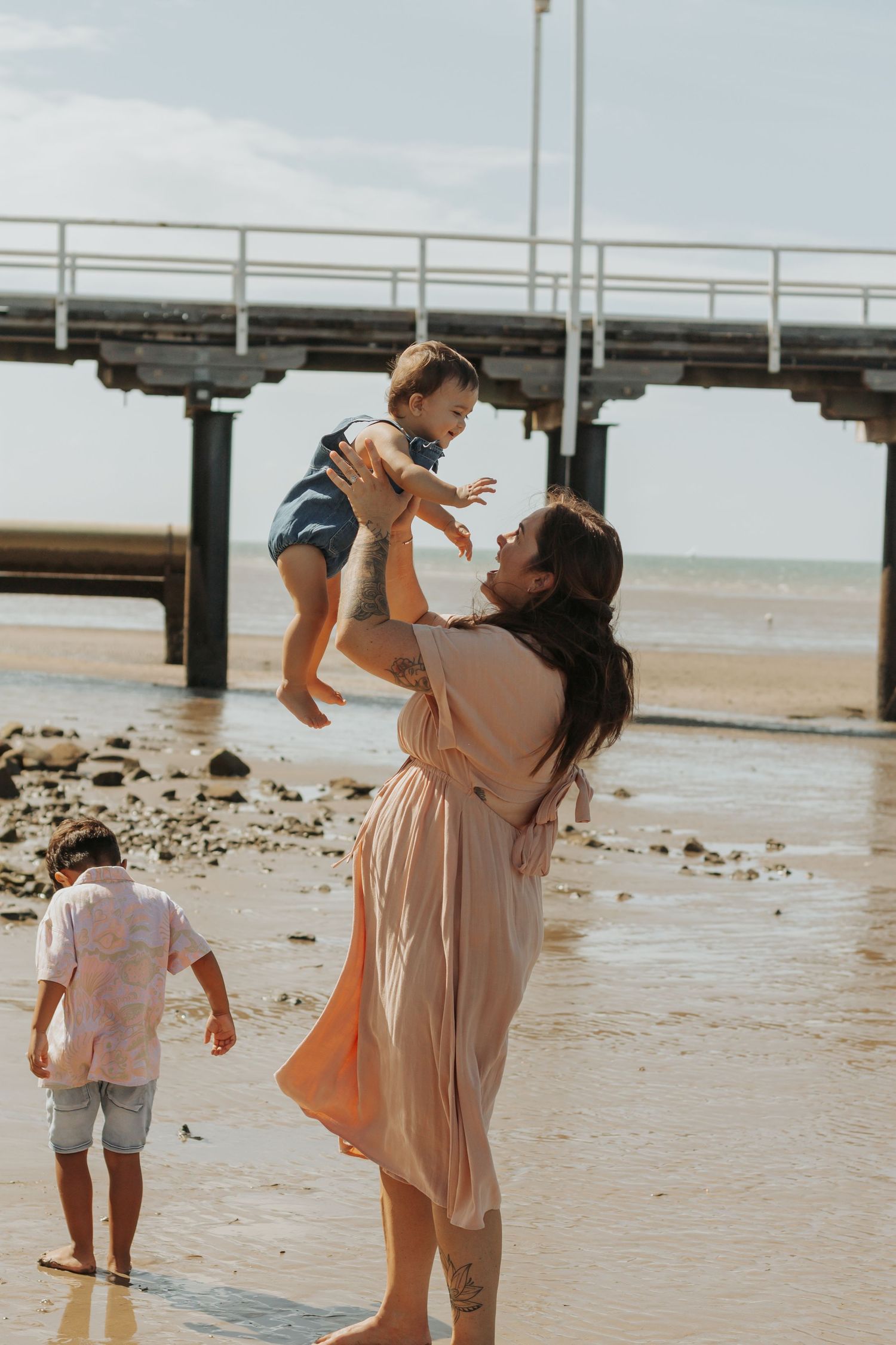 Mother and her two boys playing at the beach during a Morning family photography session in Hervey Bay.