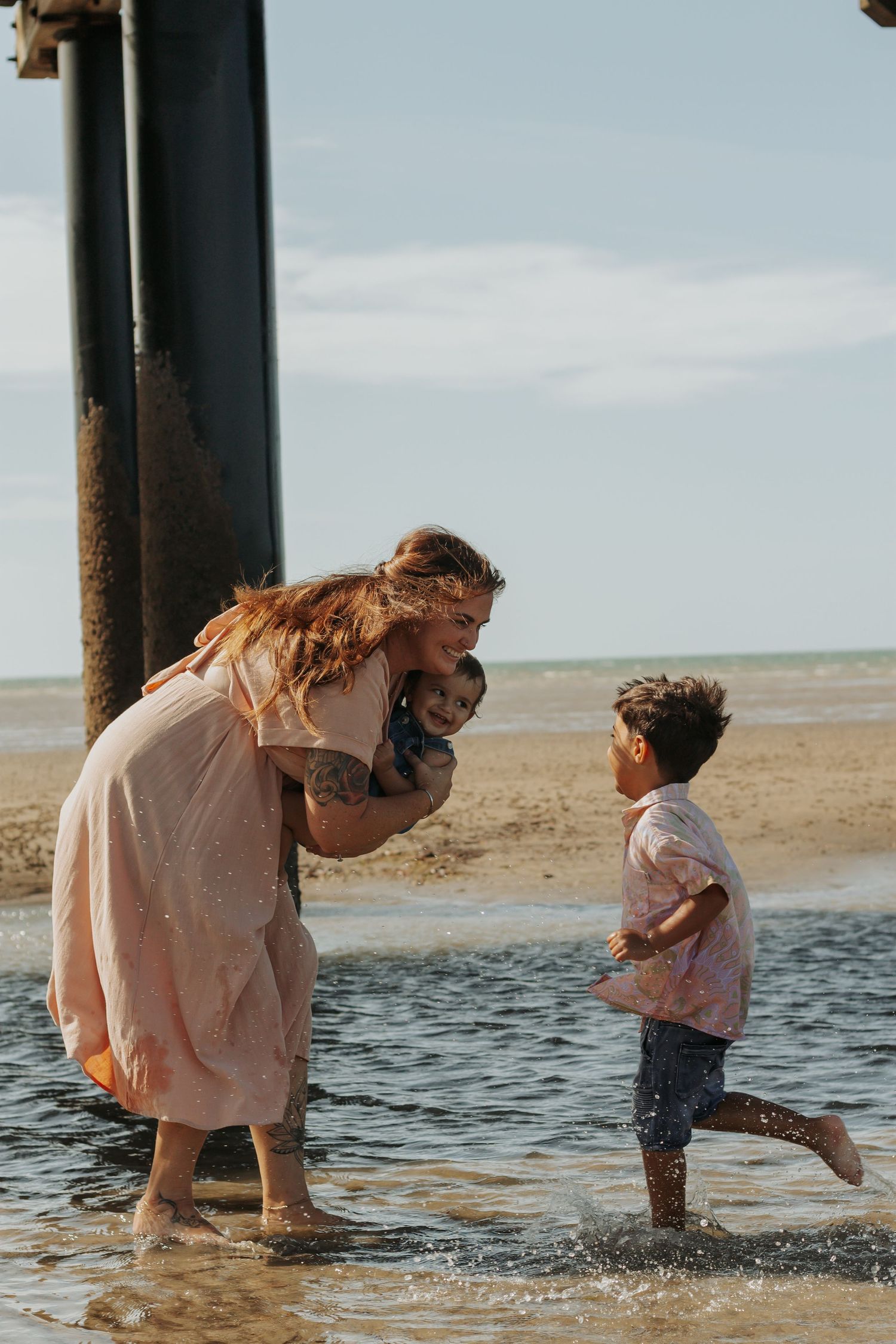 Mother and her two boys playing at the beach during a Morning family photography session in Urangan pier, Fraser Coast.