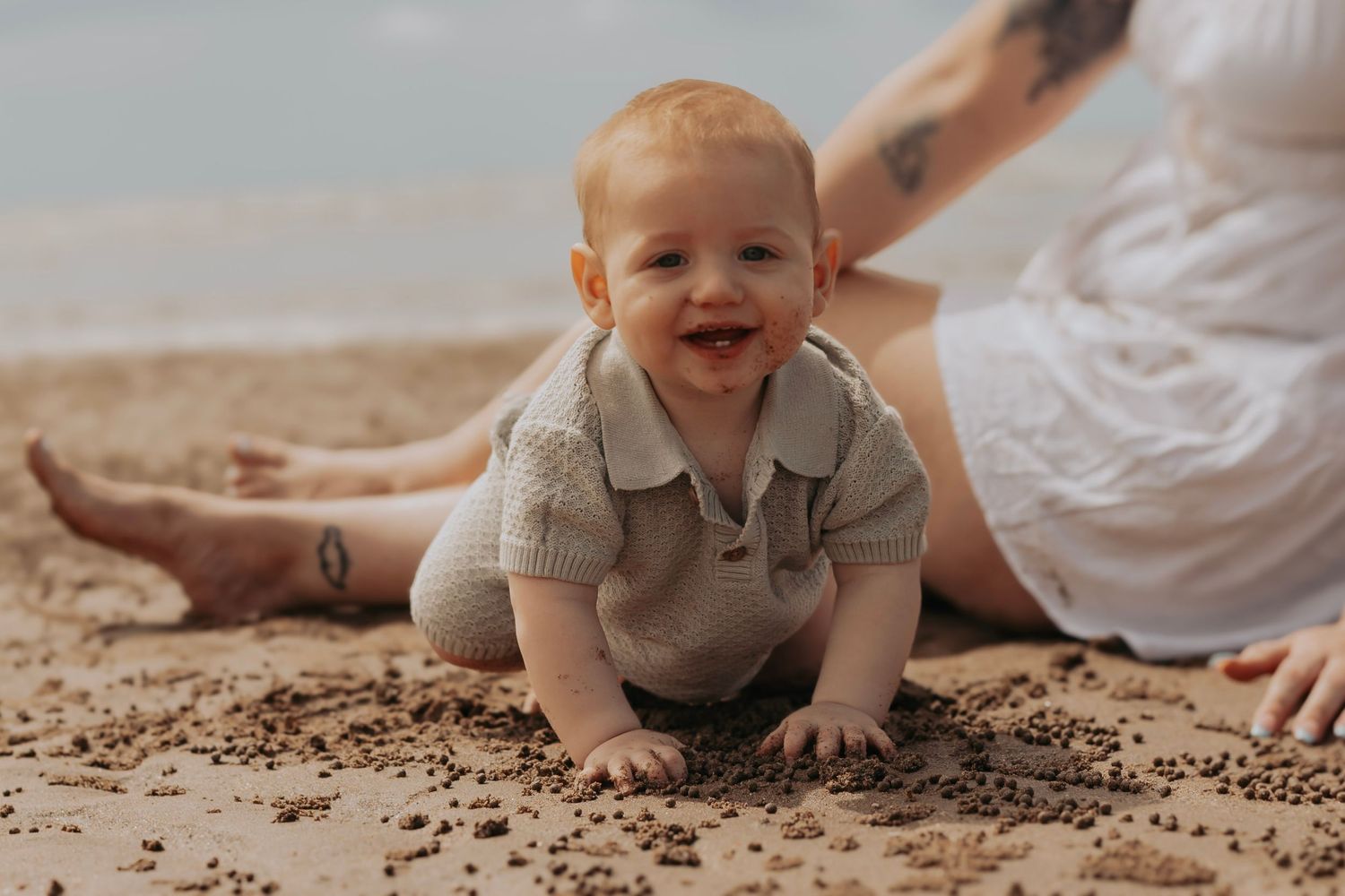 Little boy Playing in the sand at his first time at the beach in the morning. Motherhood Photographer