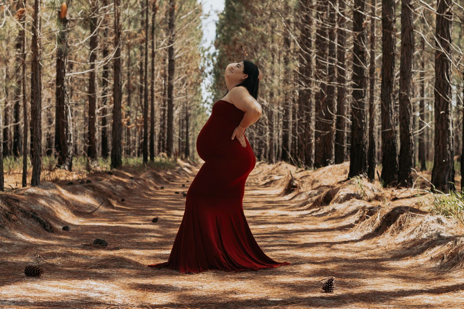 Pregnant mother standing in the Pine forest during a morning maternity photography session in Maryborough.