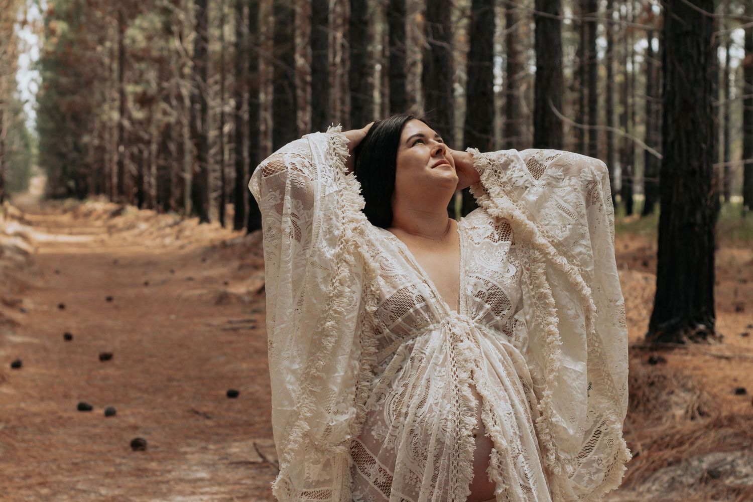 Pregnant mother standing in the Pine forest during a morning maternity photography session in Maryborough.