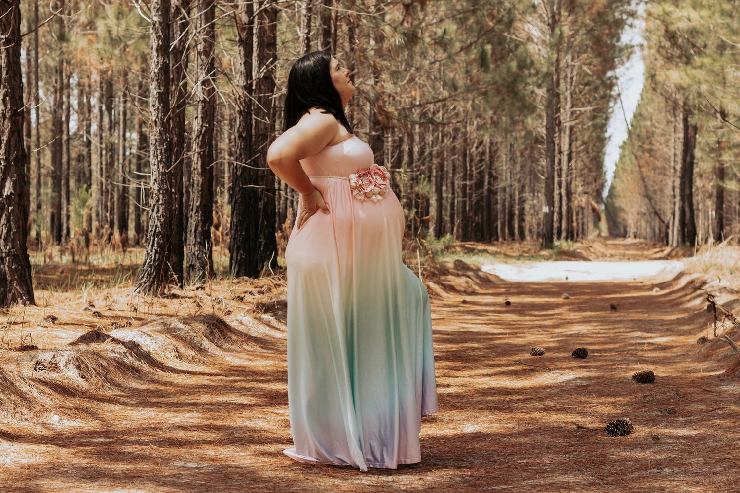Pregnant mother standing in the Pine forest during a morning maternity photography session in Maryborough.