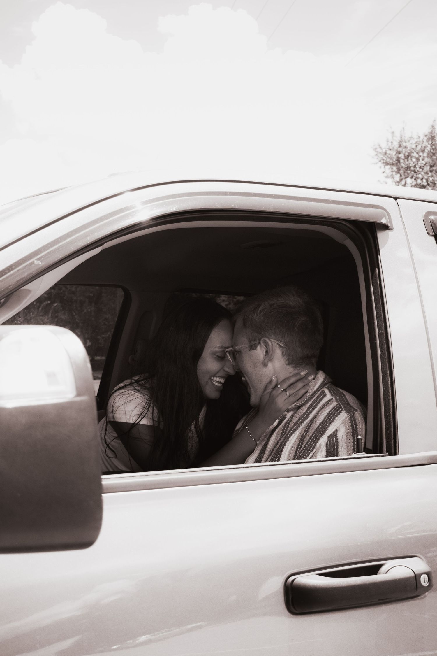 Romantic couple sharing an intimate moment together inside a pickup truck cab.