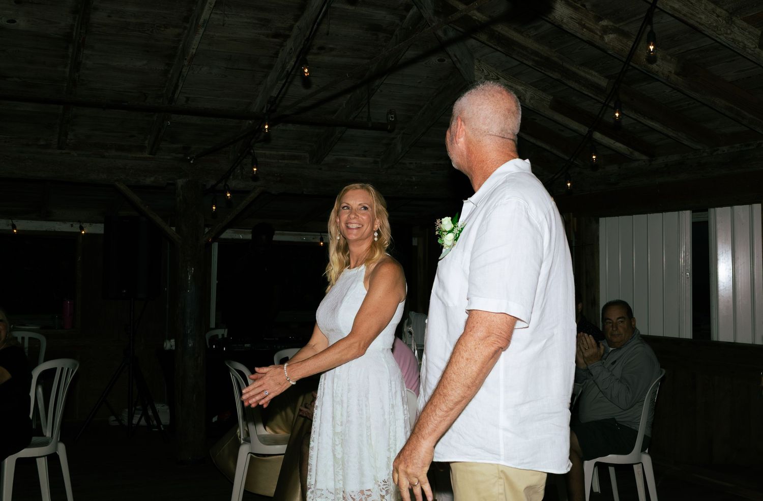 Newlywed couple sharing a happy moment together during indoor wedding reception.