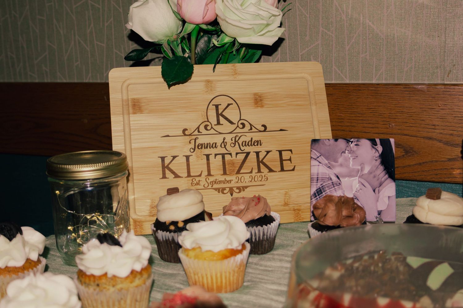Personalized Klitzke wedding cutting board gift displayed with cupcakes and desserts.