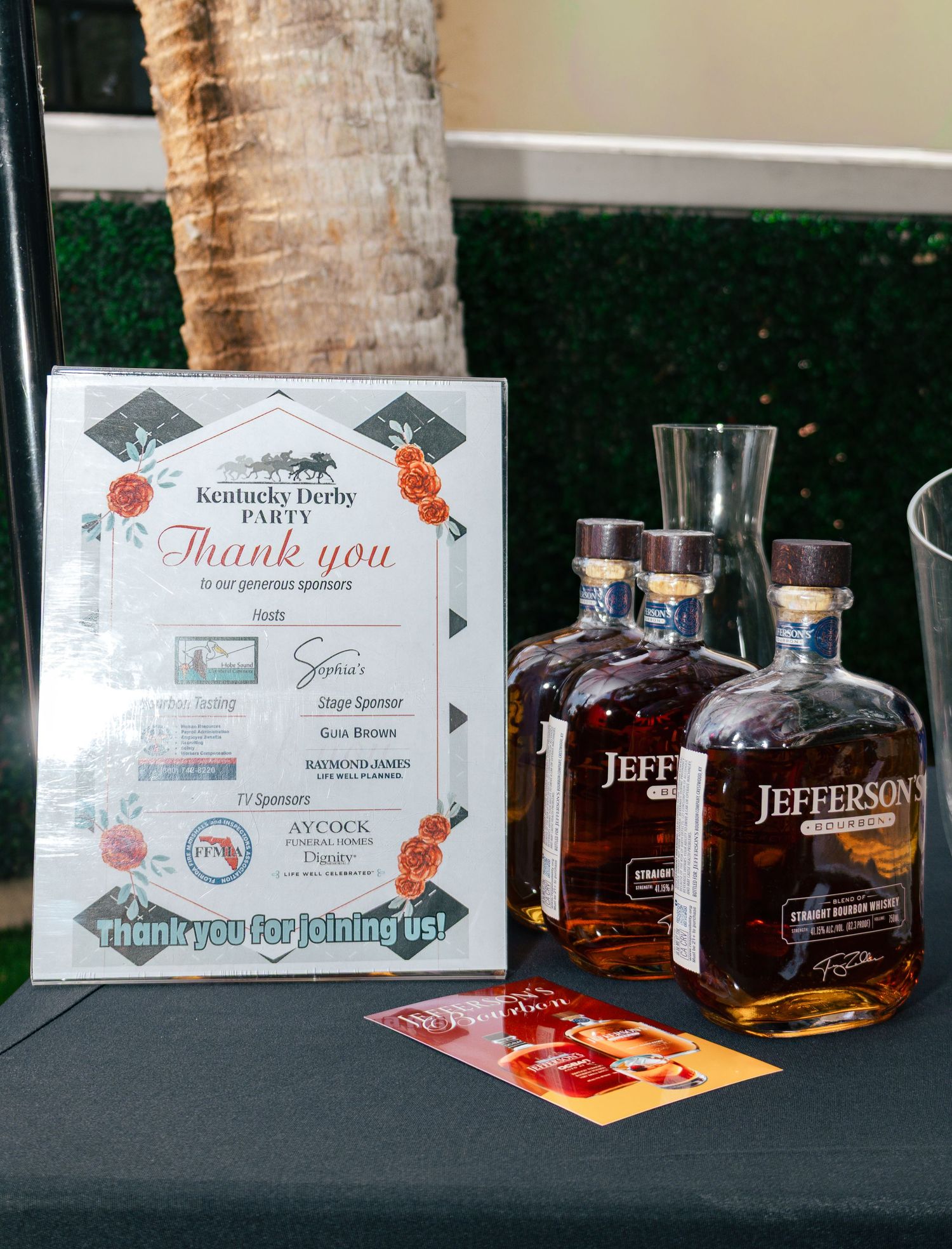 Jefferson's bourbon bottles displayed at a Kentucky Derby Party thank you sponsor sign on a black table.