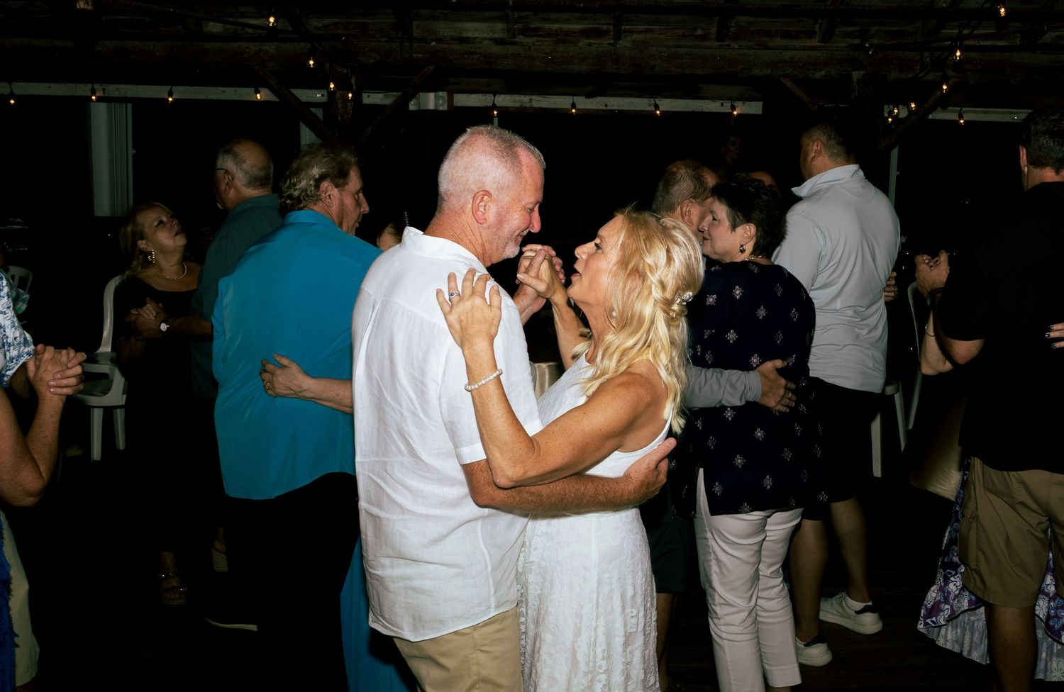 Couple sharing a romantic dance at an evening wedding reception party.