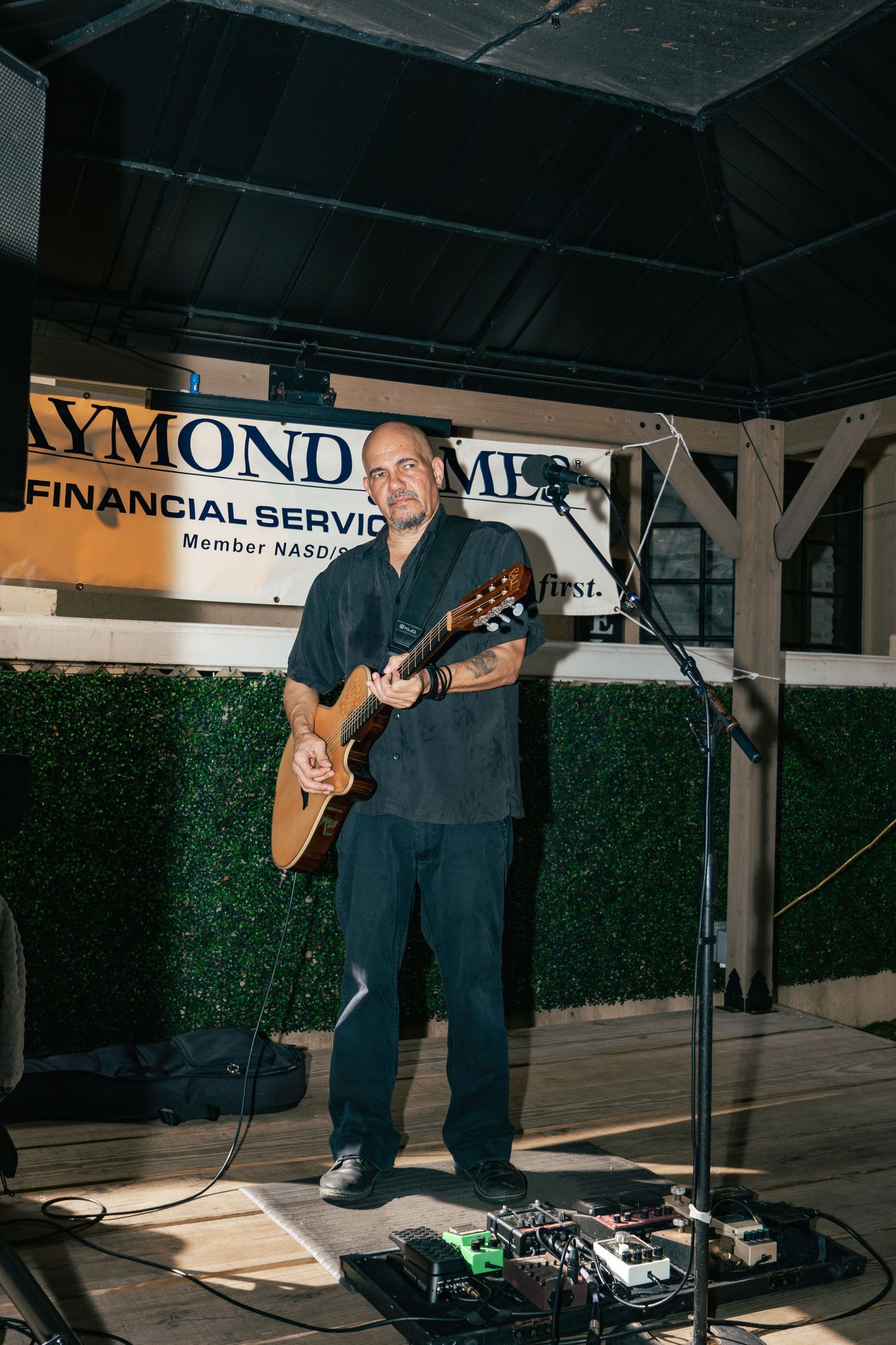 Male guitarist performs on outdoor stage at Raymond James Financial Services Kentucky Derby event.