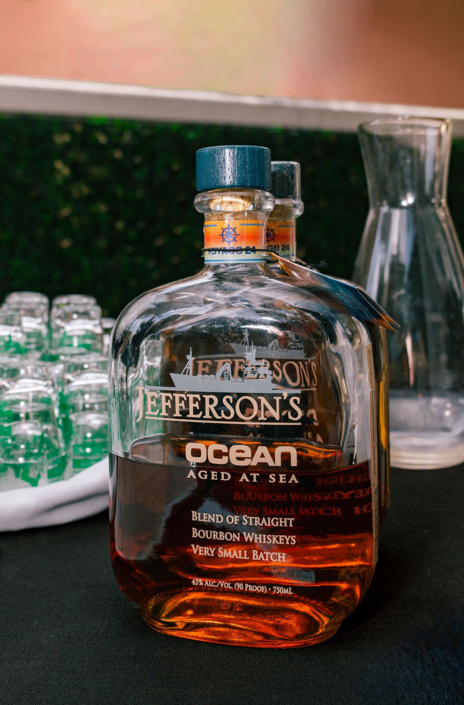 Jefferson's Ocean Aged at Sea bourbon whiskey bottle displayed on a bar table at an event.