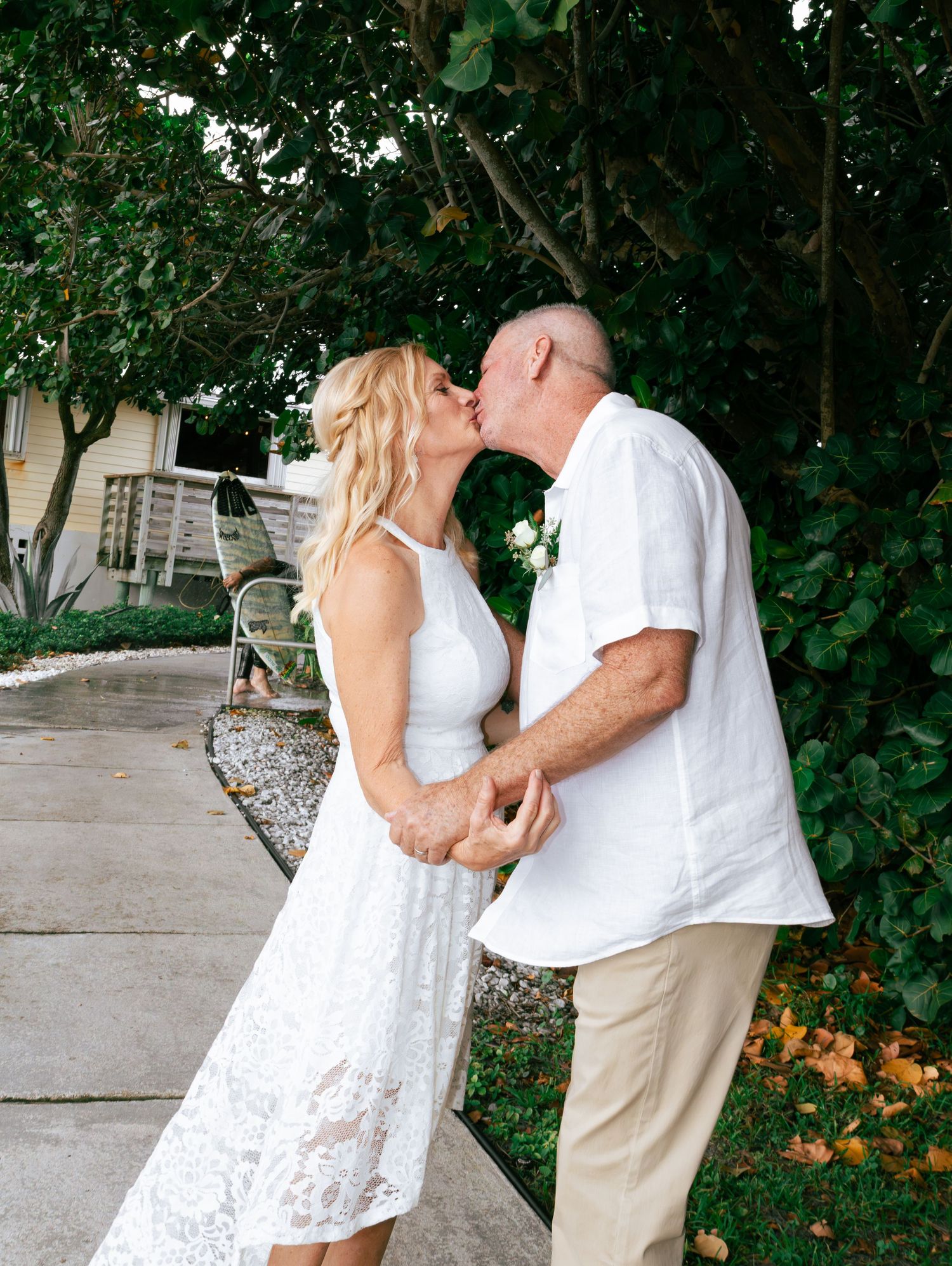 Newlywed couple sharing first kiss outdoors after intimate garden wedding ceremony.