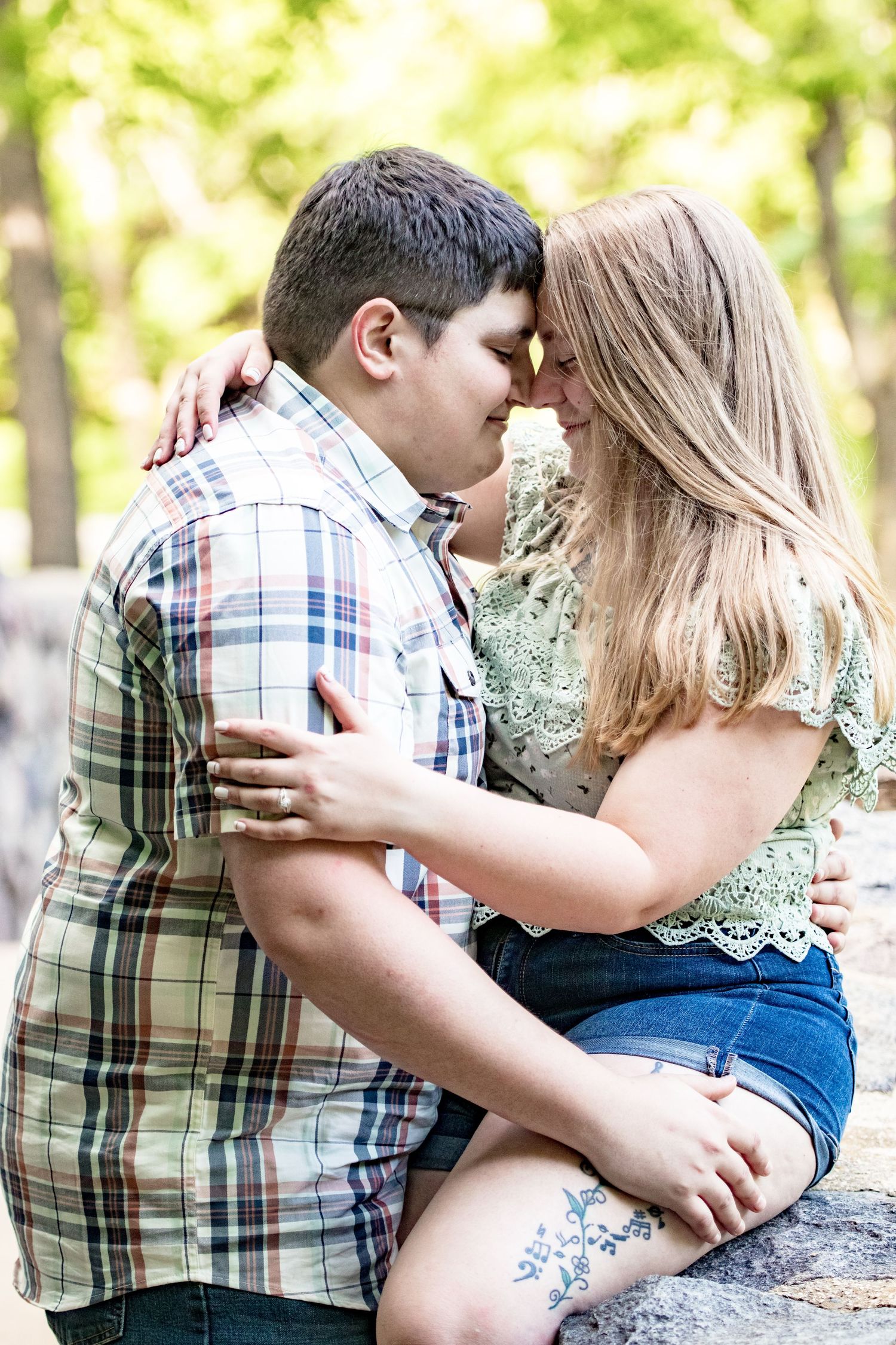 A romantic couple shares an intimate moment while sitting outdoors.