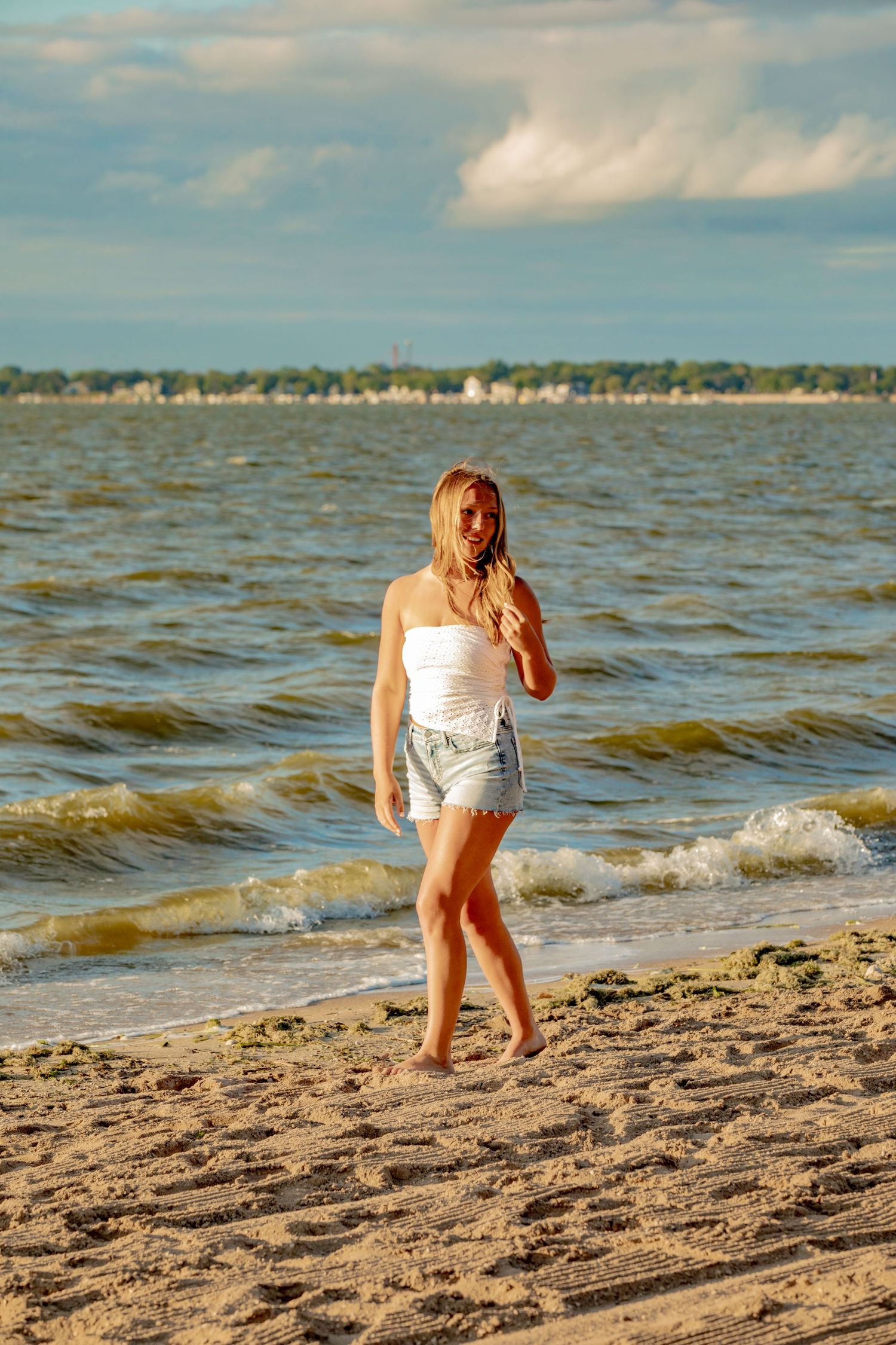 Beach lifestyle series showing someone playing with a ball on sandy shoreline at sunset.