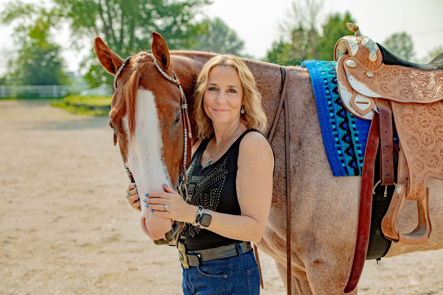 Close up shots of blue and turquoise decorated western saddles and riding accessories in an arena setting.