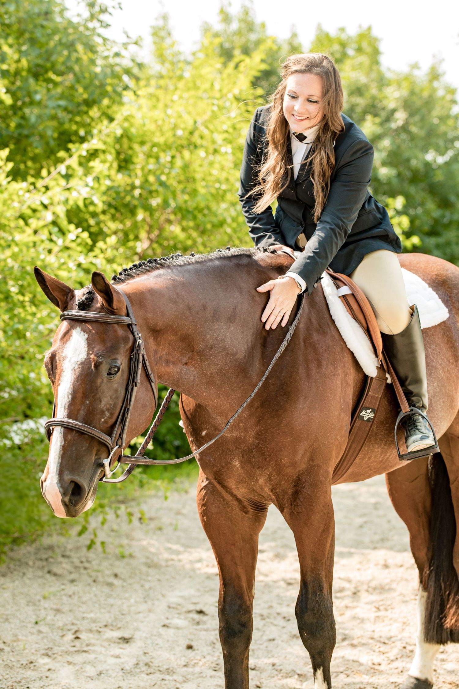 Rider in classic show attire sits mounted on bay horse with English tack.