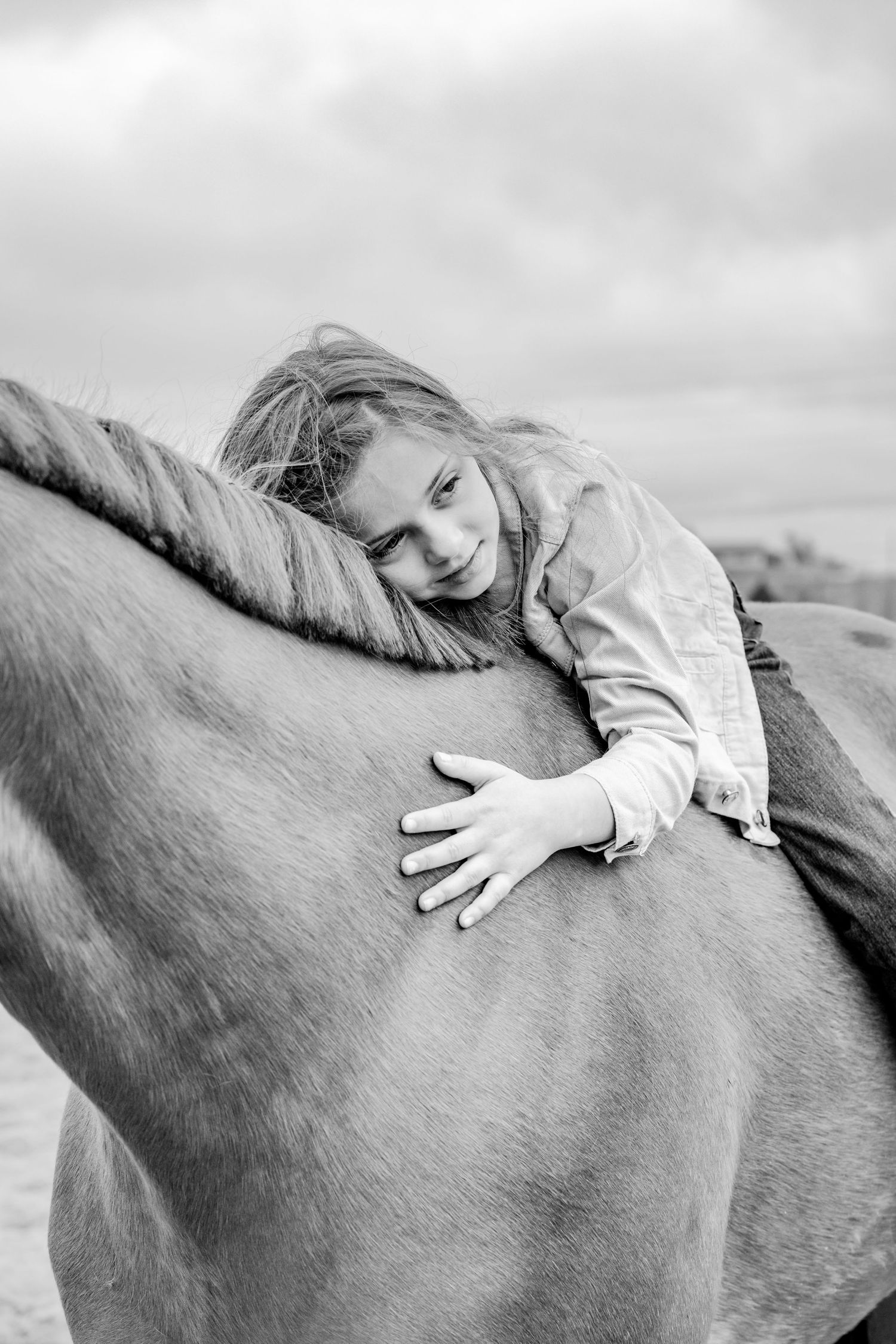 Artistic black and white photos showing gentle interaction with a horse's back.