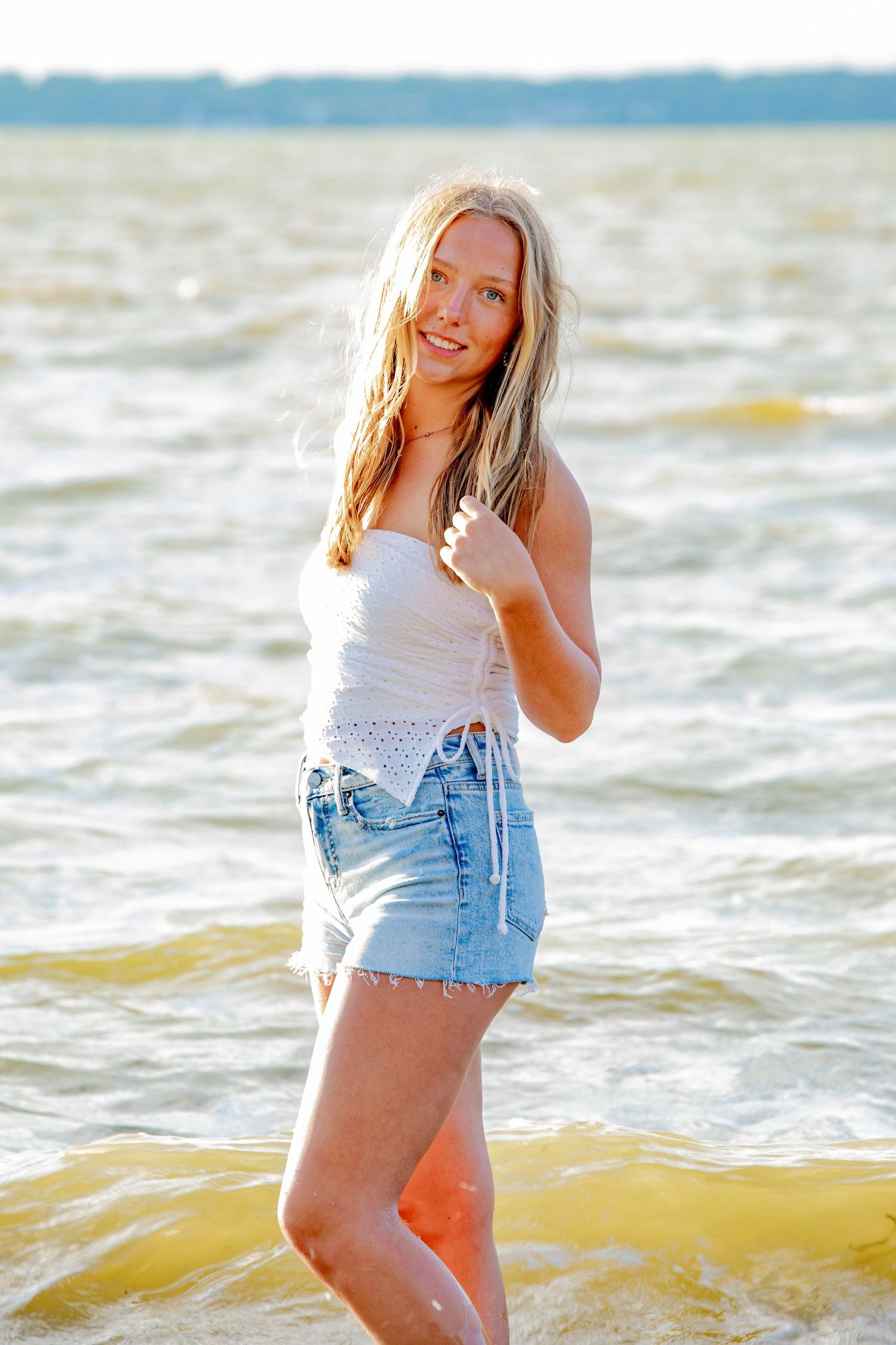Beachwear fashion portraits captured in warm sunlight with ocean waves in background.
