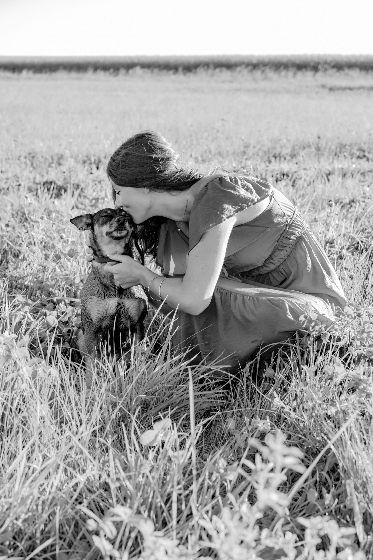 A photographer lies in black and white grass while taking creative shots.