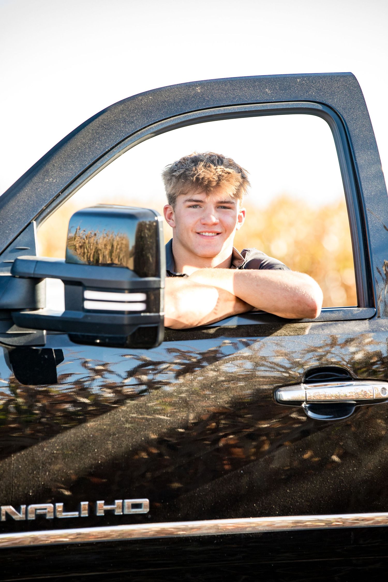 Looking through truck window at sunset with cornfield in background.