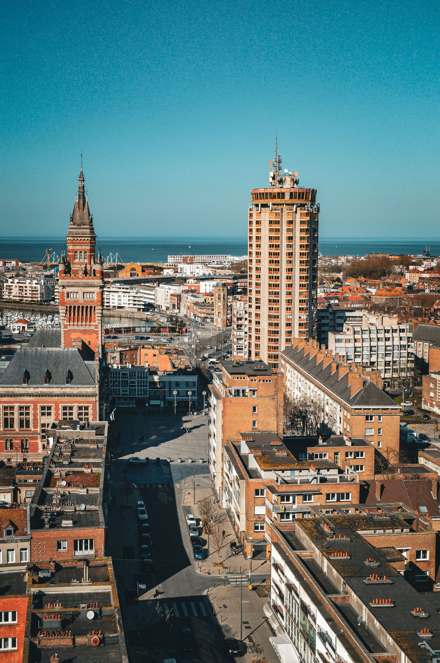 Panoramic cityscape with modern buildings and blue sky showing urban development.